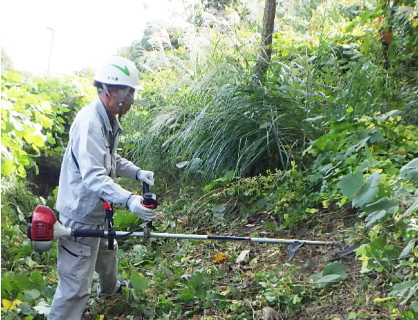 草を刈る男性